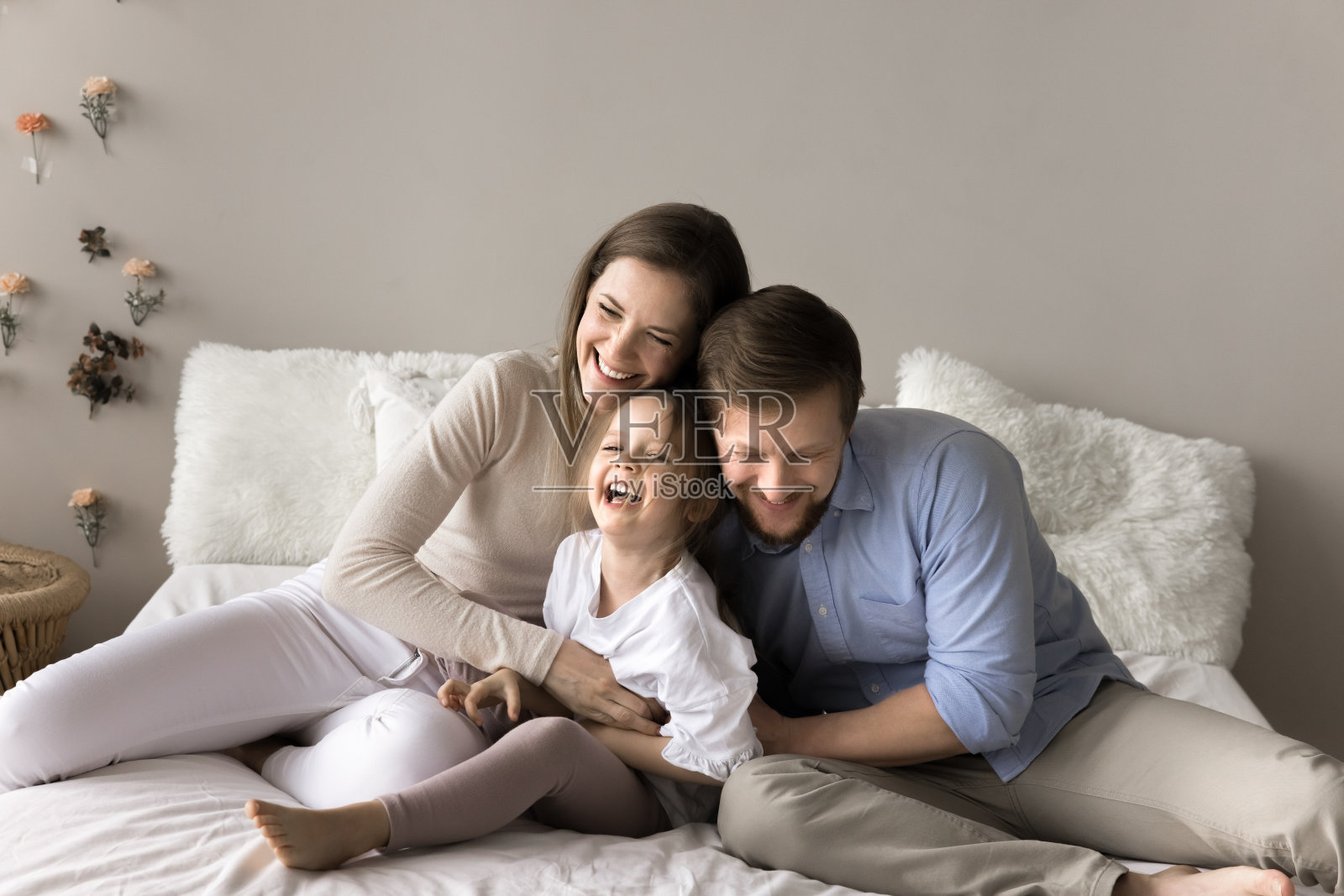 年轻的笑父母花时间与学龄前的女儿照片摄影图片