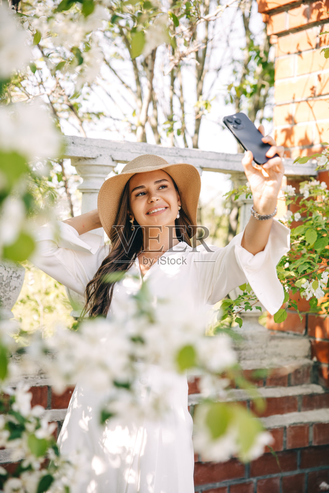 一个女孩在盛开的花园里自拍照片摄影图片