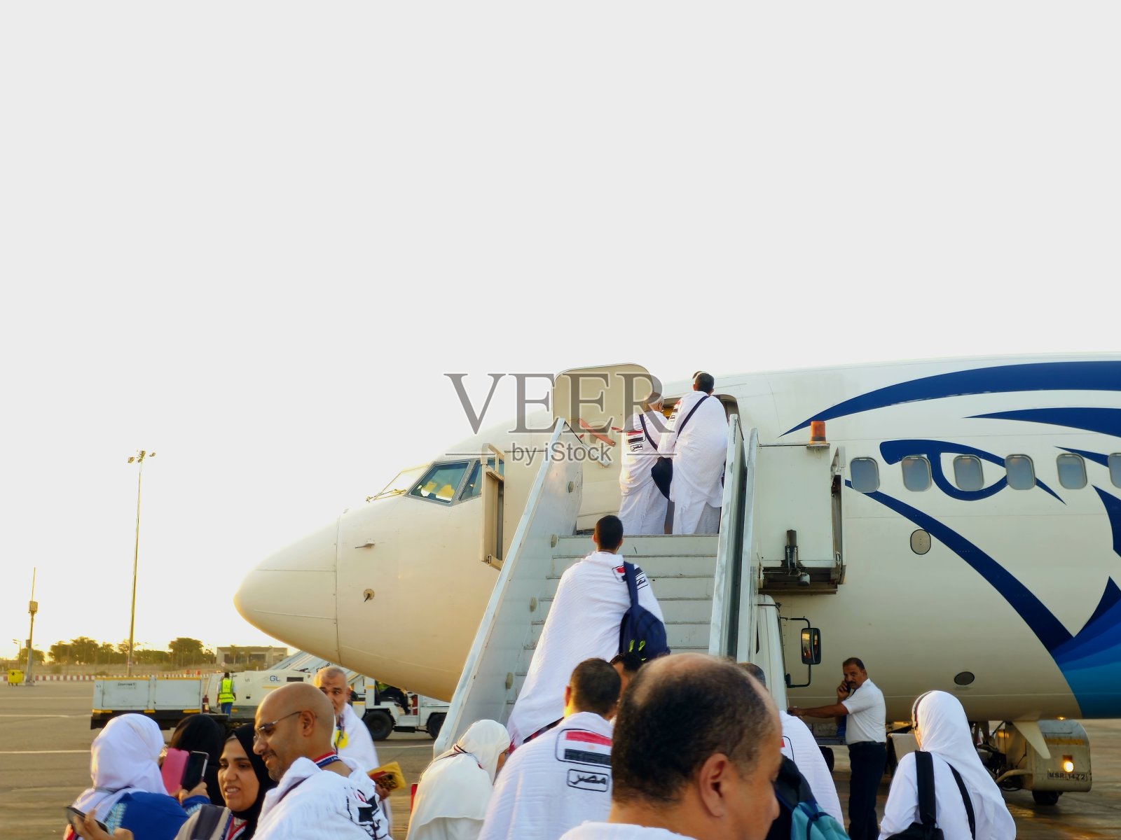 开罗国际机场的埃及航空飞机，朝觐者身着戒衣前往沙特阿拉伯朝觐，朝觐和副朝伊斯兰概念照片摄影图片