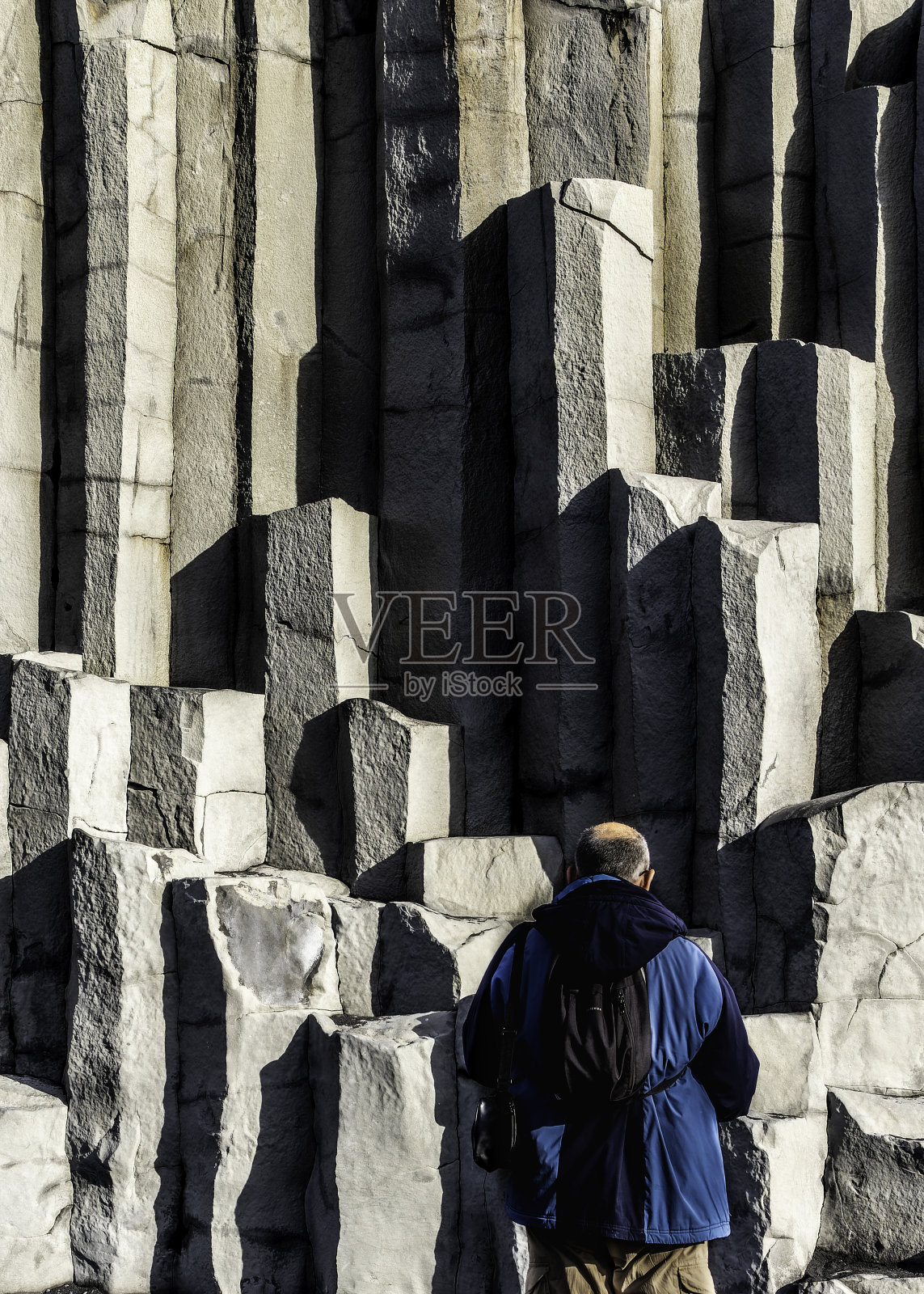 冰岛，一名男子站在加达尔玄武岩石柱前照片摄影图片
