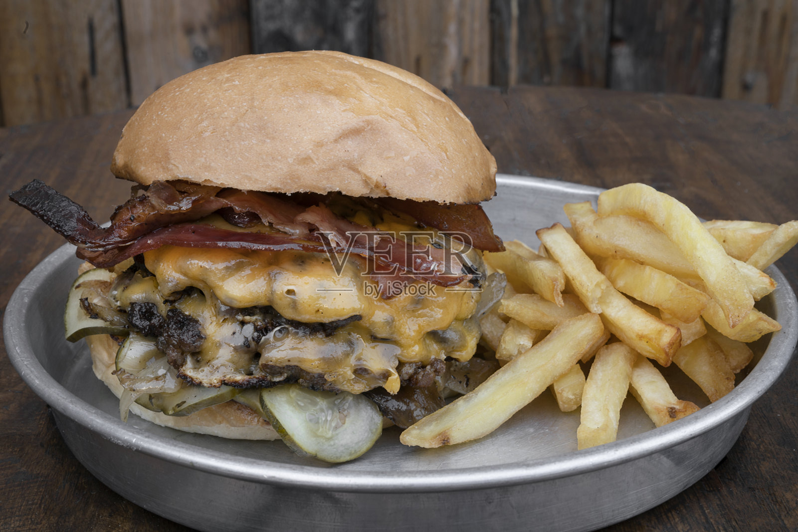 培根切达芝士汉堡配薯条和质朴的木制背景照片摄影图片