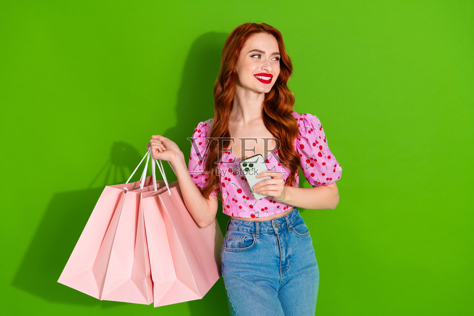 照片上迷人积极的女人穿着印花上衣，上升的购物者打字现代设备空白空间孤立的绿色背景照片摄影图片