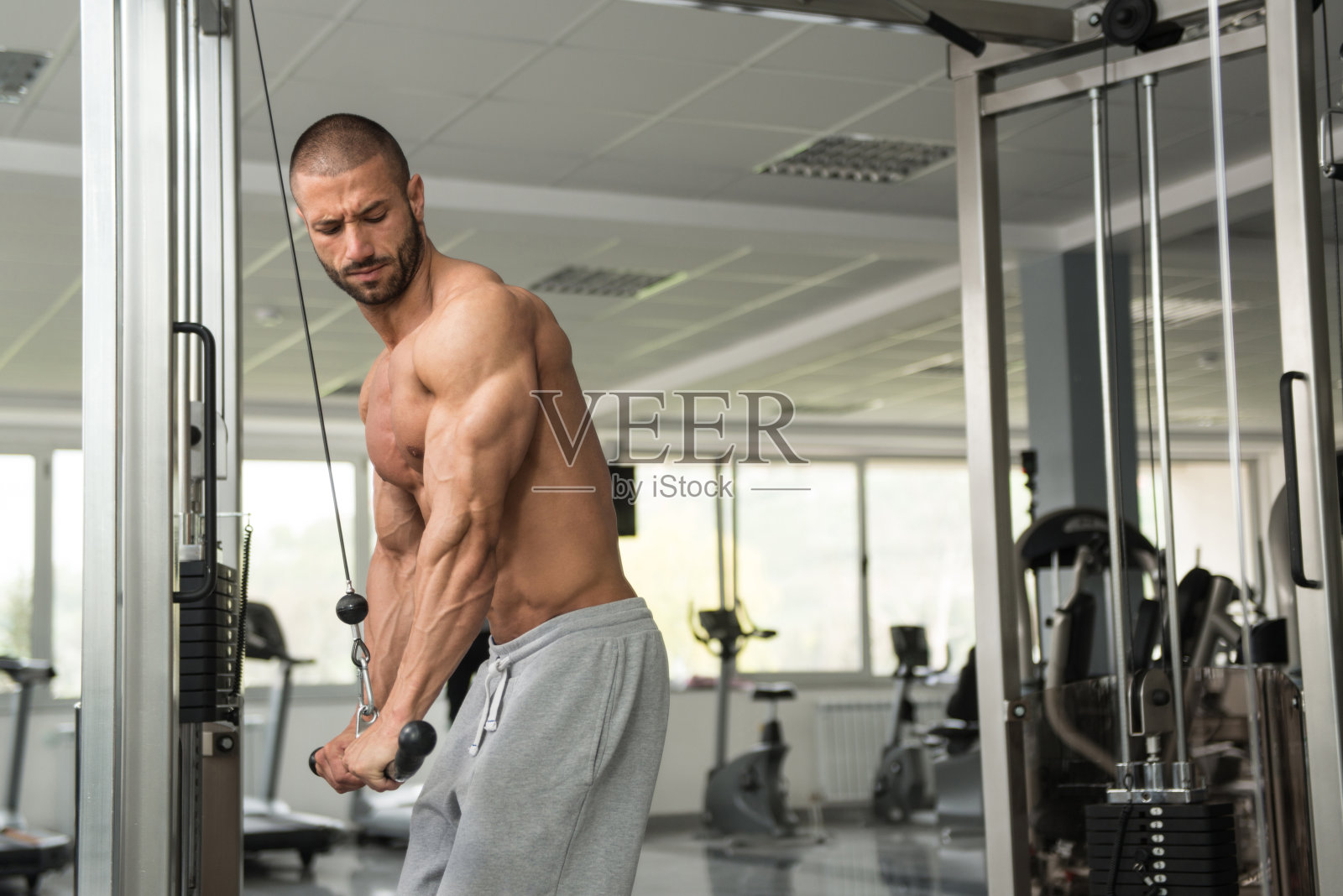 健美运动员用钢索锻炼肱三头肌照片摄影图片