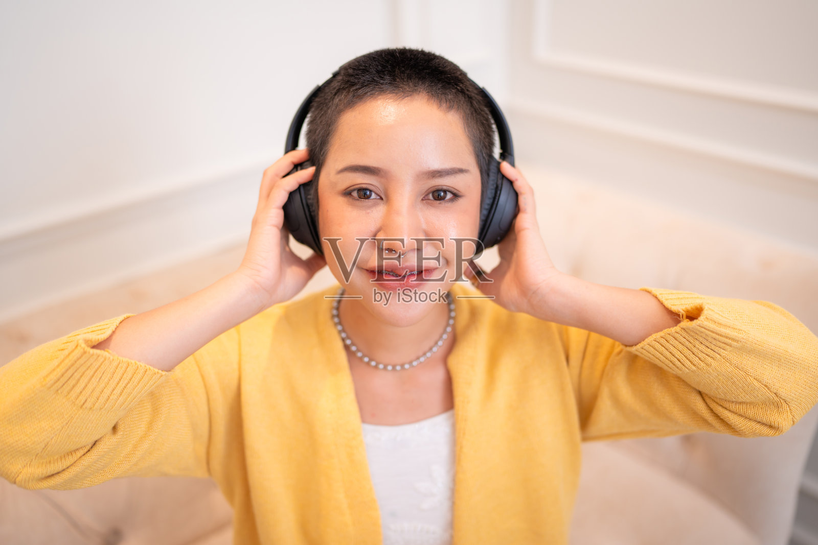 漂亮的年轻亚洲女人戴着耳机的肖像。照片摄影图片