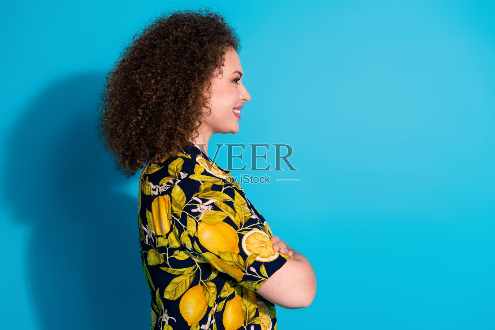 漂亮可爱的开朗女孩穿着热带时尚印花衣服的照片，在蓝色背景上呈现出孤立的空白空间照片摄影图片