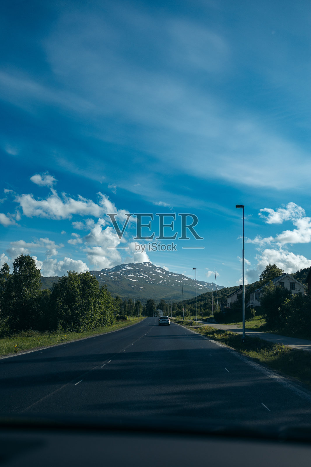 在乡间的一条路上，蓝天下一座山矗立在前方照片摄影图片