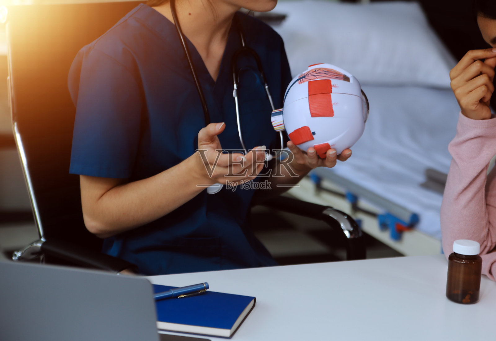 诊所里的眼科医生，桌上的部分眼模型，眼孔样本照片摄影图片