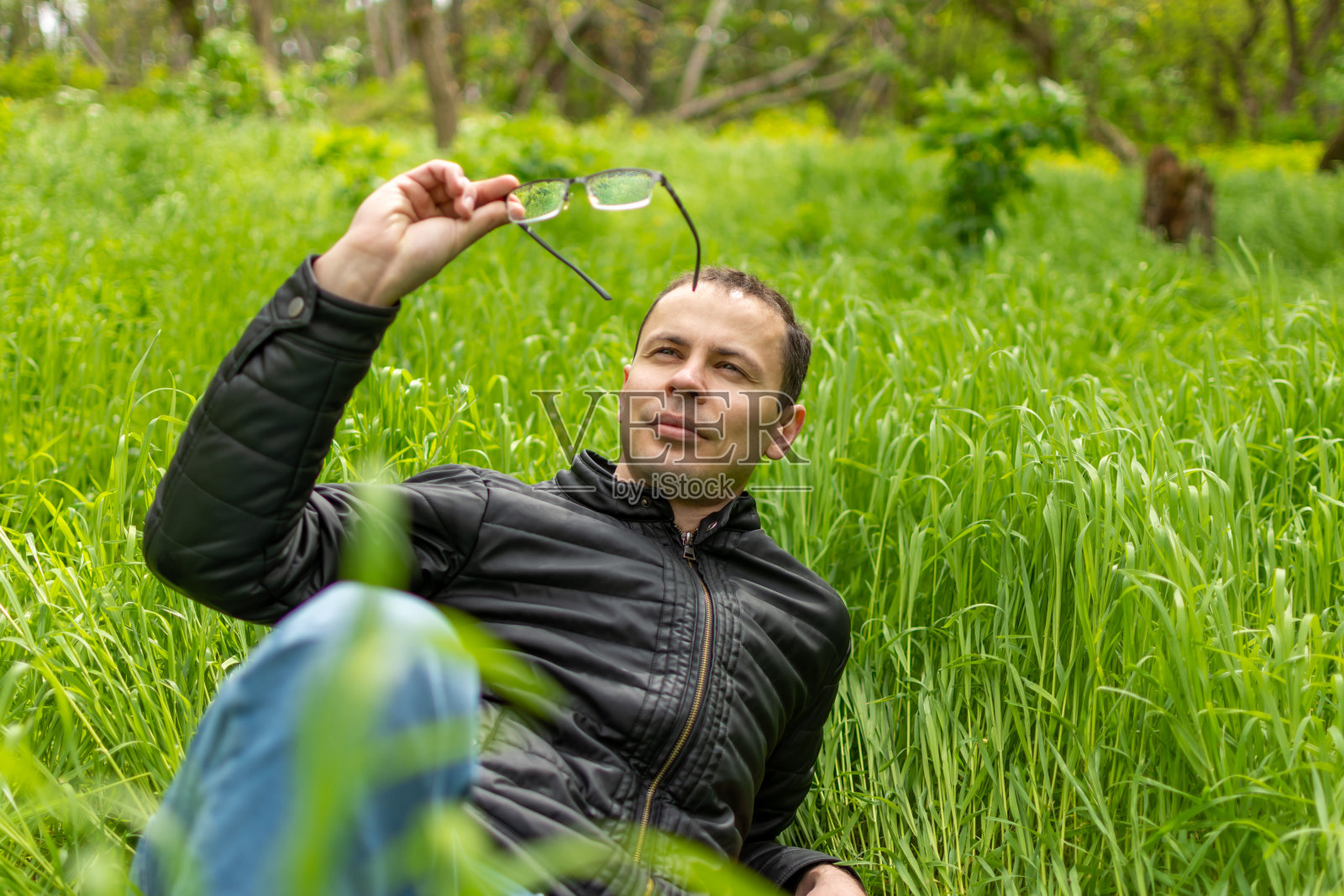 一个人躺在草地上，头上戴着眼镜照片摄影图片