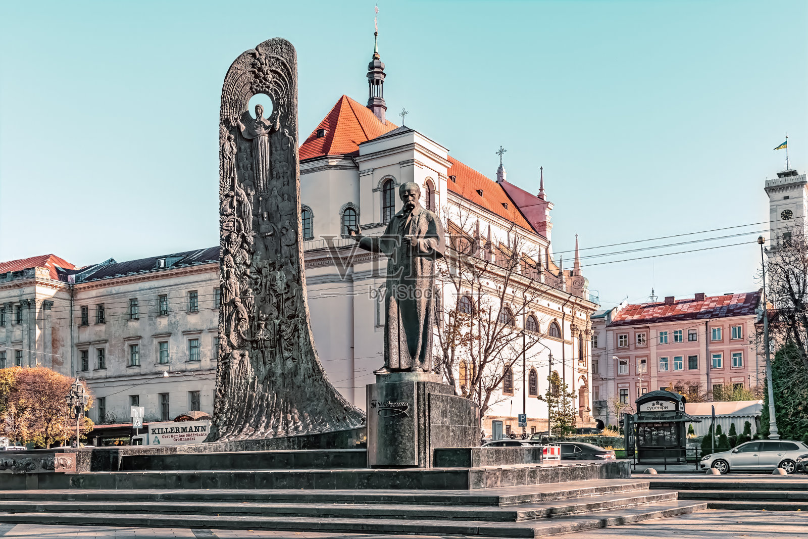 利沃夫耶稣会教堂背景上塔拉斯舍甫琴科雕像和民族复兴浪潮石碑的侧视图照片摄影图片