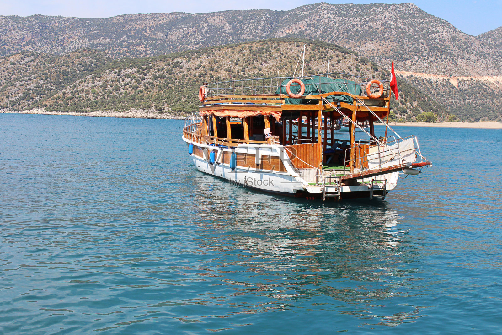 在阳光明媚的夏天，游船在蓝色的大海上漂浮。侧视图。山水有游艇、山峦、碧水。海上、旅游理念照片摄影图片