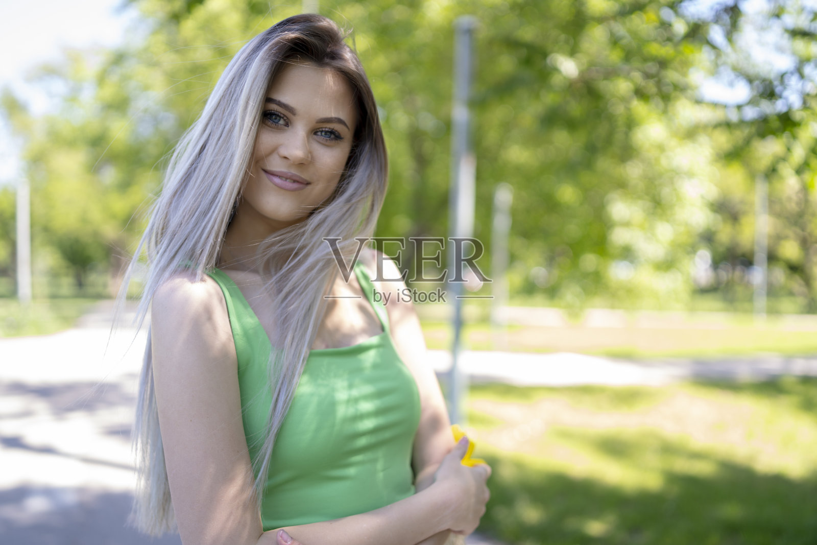 一个女人拎着网眼线编织的购物袋走在外面照片摄影图片