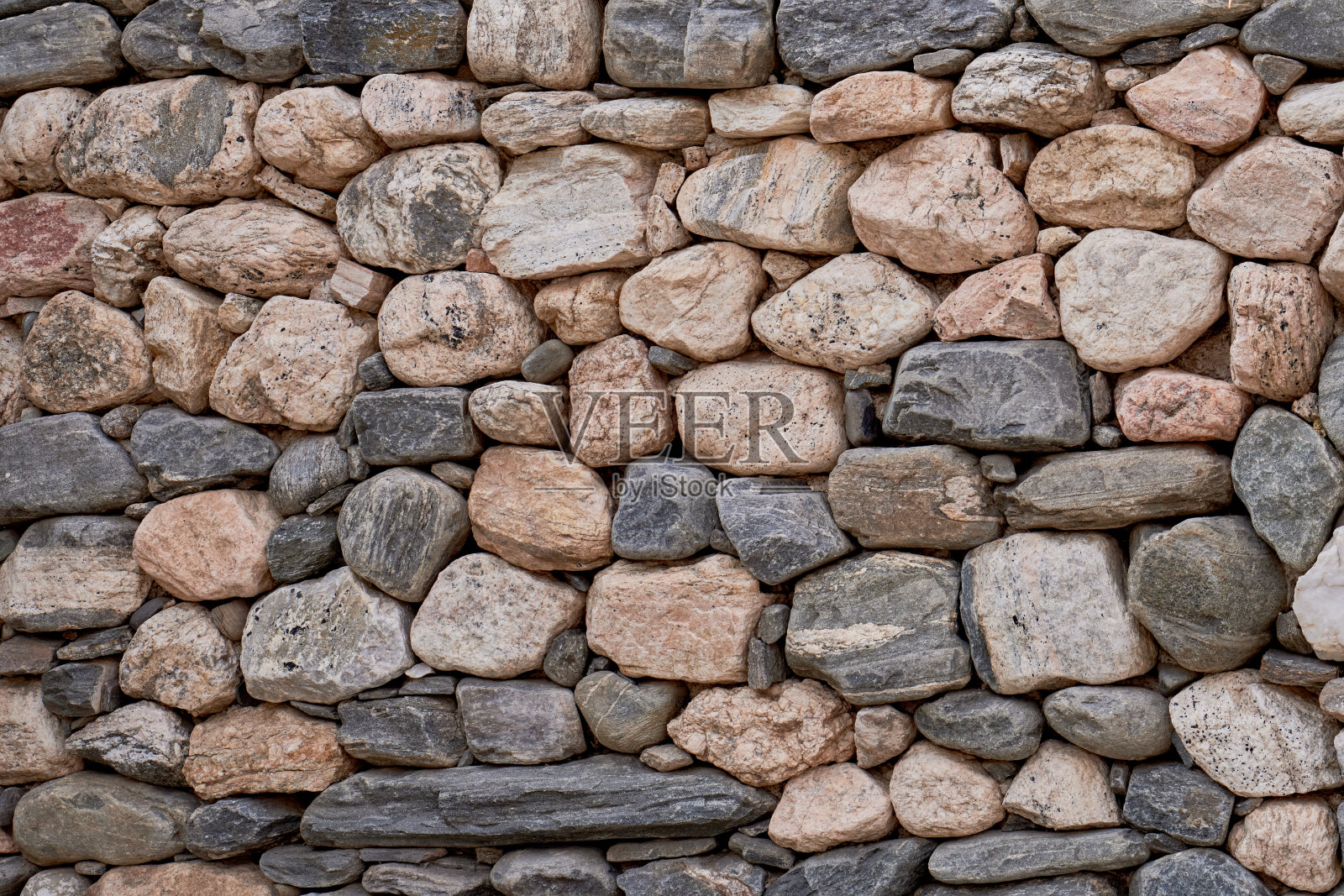 石墙纹理背景采用不同大小的灰色和米色石材，照片摄影图片