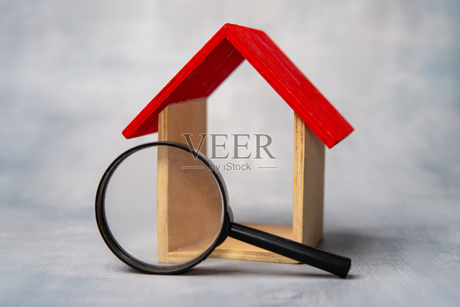 微型房子前的放大镜。照片摄影图片