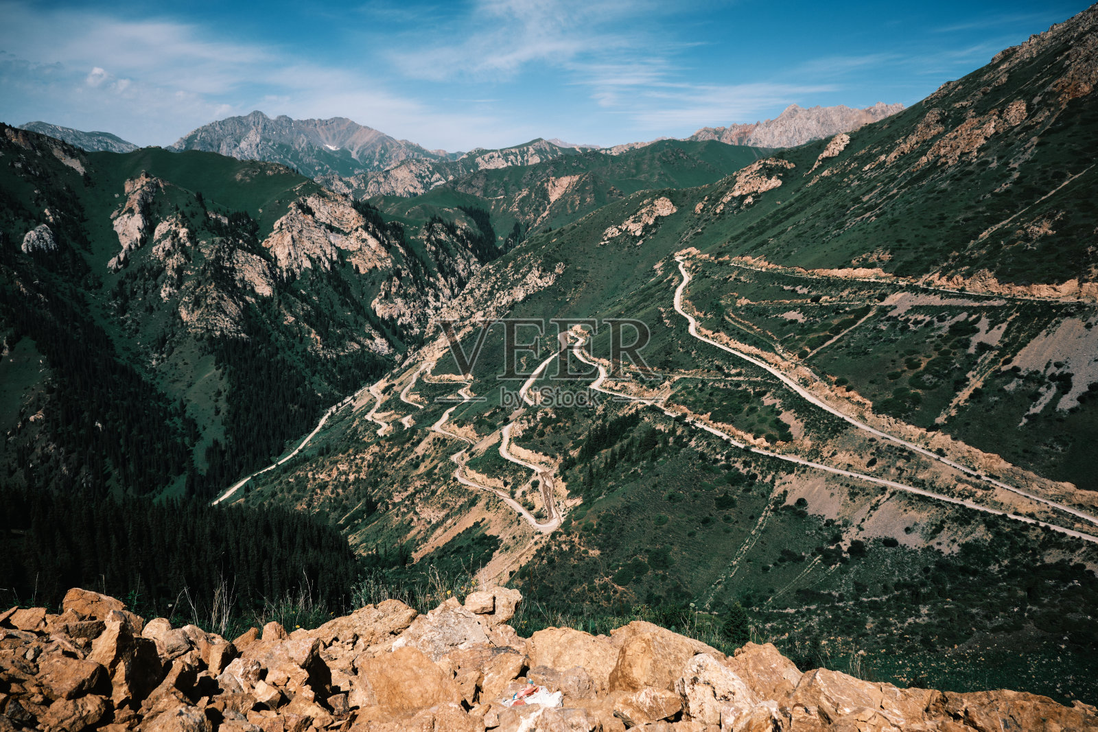 绿色的山口，蜿蜒的道路通往山顶照片摄影图片
