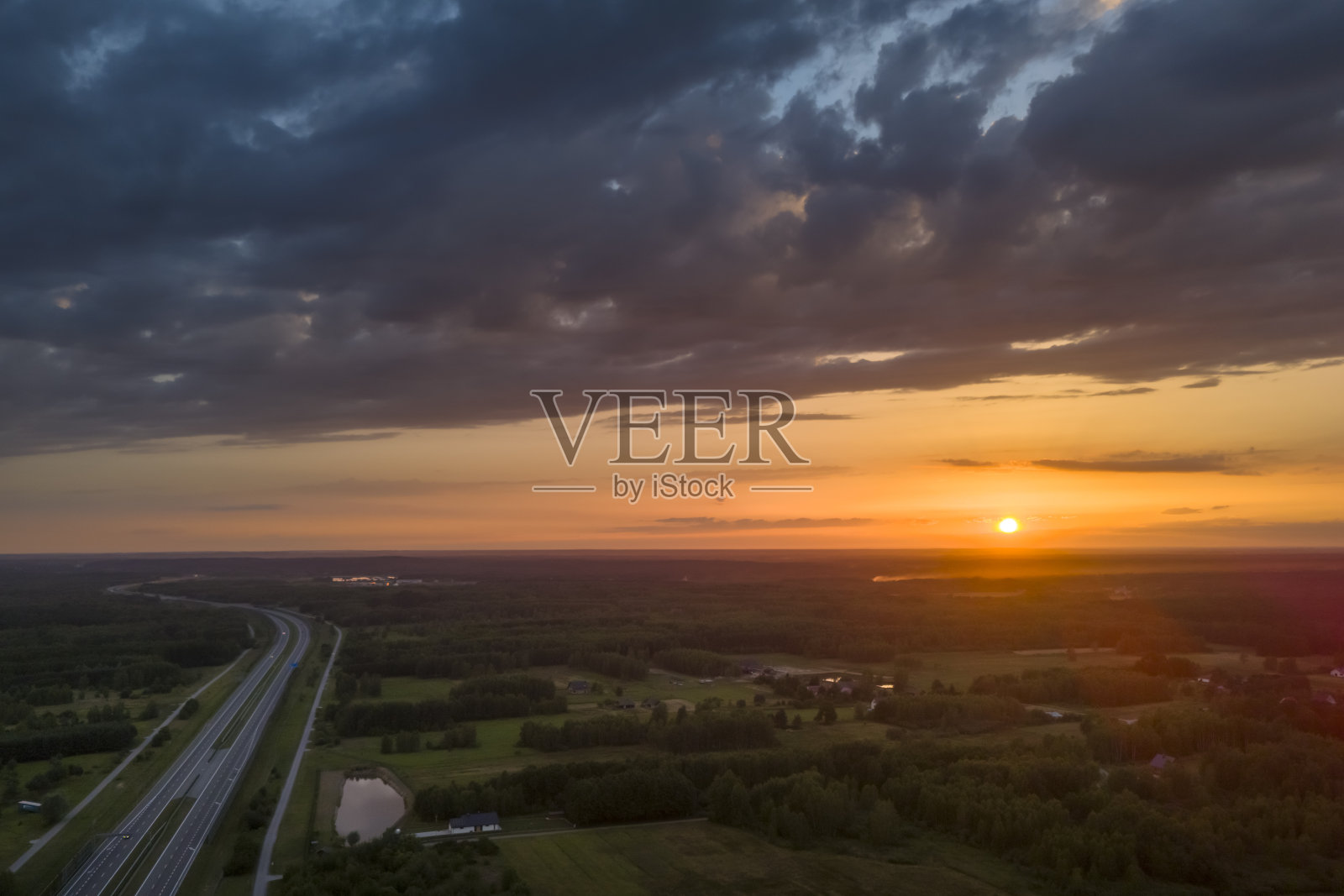 公路、桥梁和地平线上日落的鸟瞰图。旅游、交通和道路、公路建设理念照片摄影图片