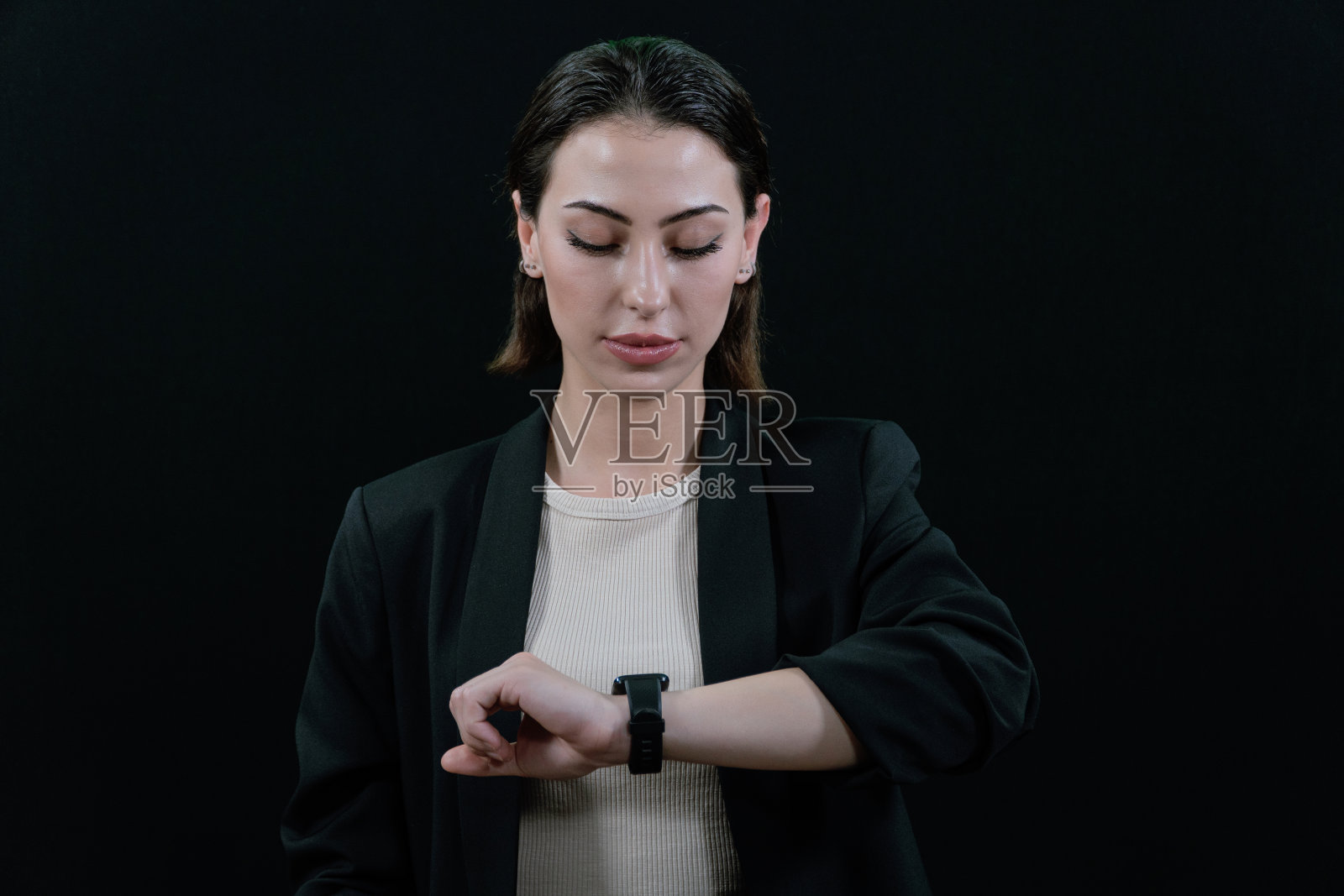 商务人士在办公室工作时使用智能手表。使用智能手表的女商人的手特写。黑色背景。照片摄影图片