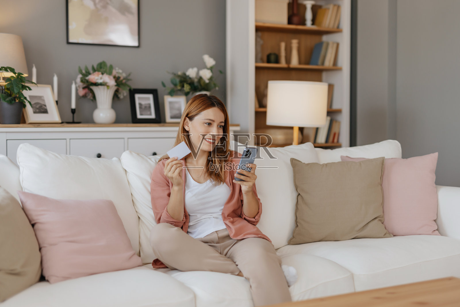年轻女子在家用信用卡网购。照片摄影图片