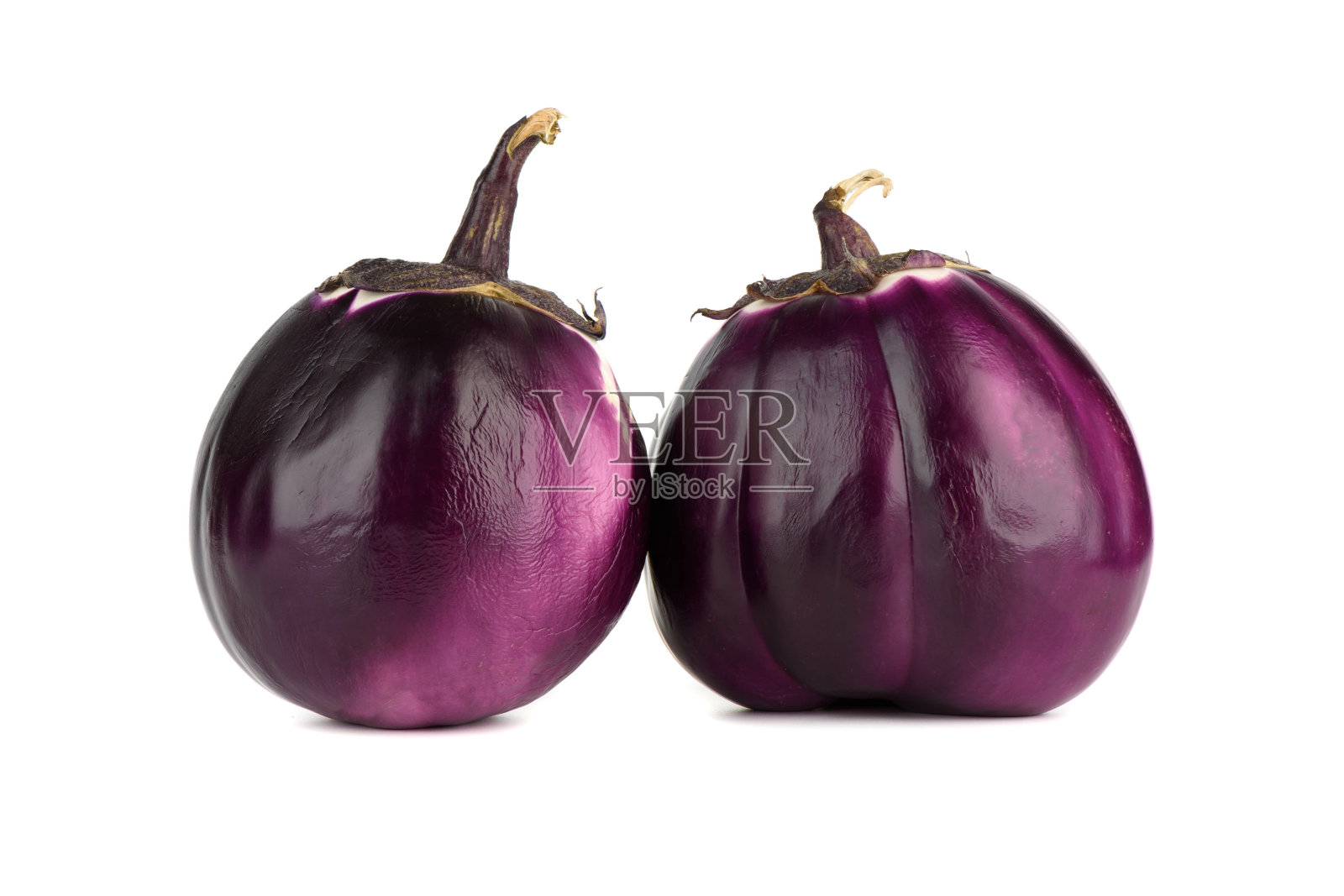 白色背景上两个成熟的球形茄子的特写。照片摄影图片