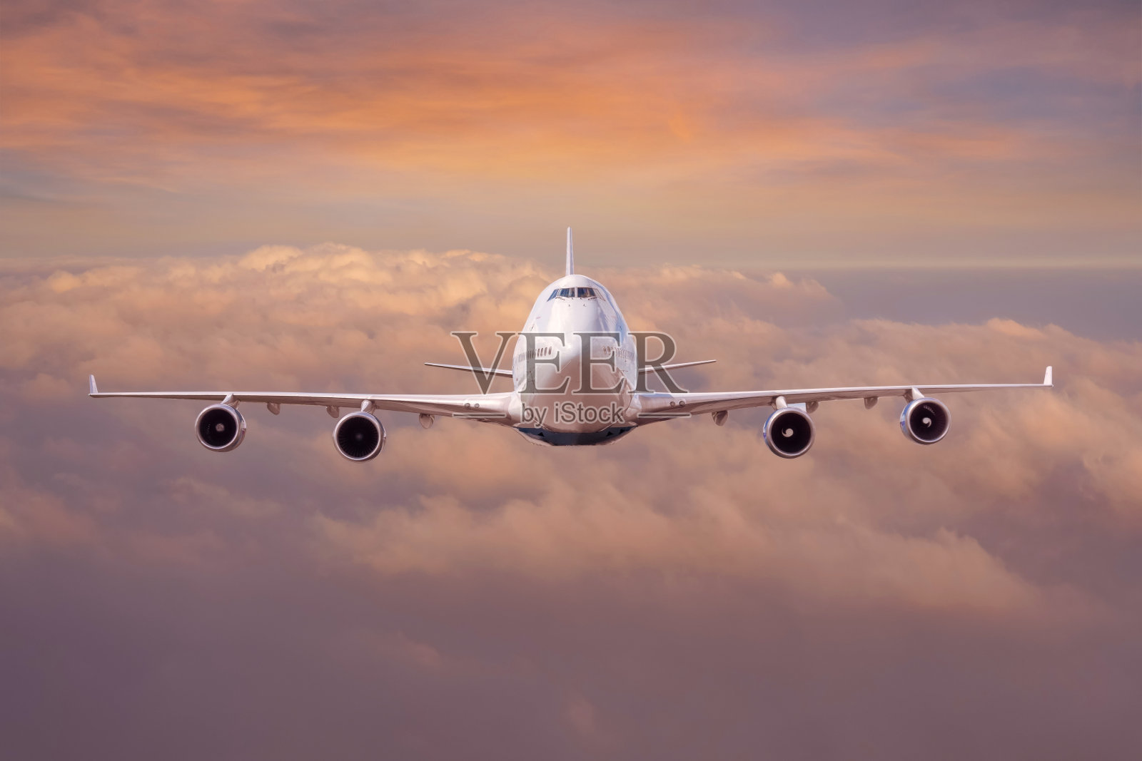 民航客机在飞行高度高空飞行，云层之上是橘黄色的夕阳天空。照片摄影图片