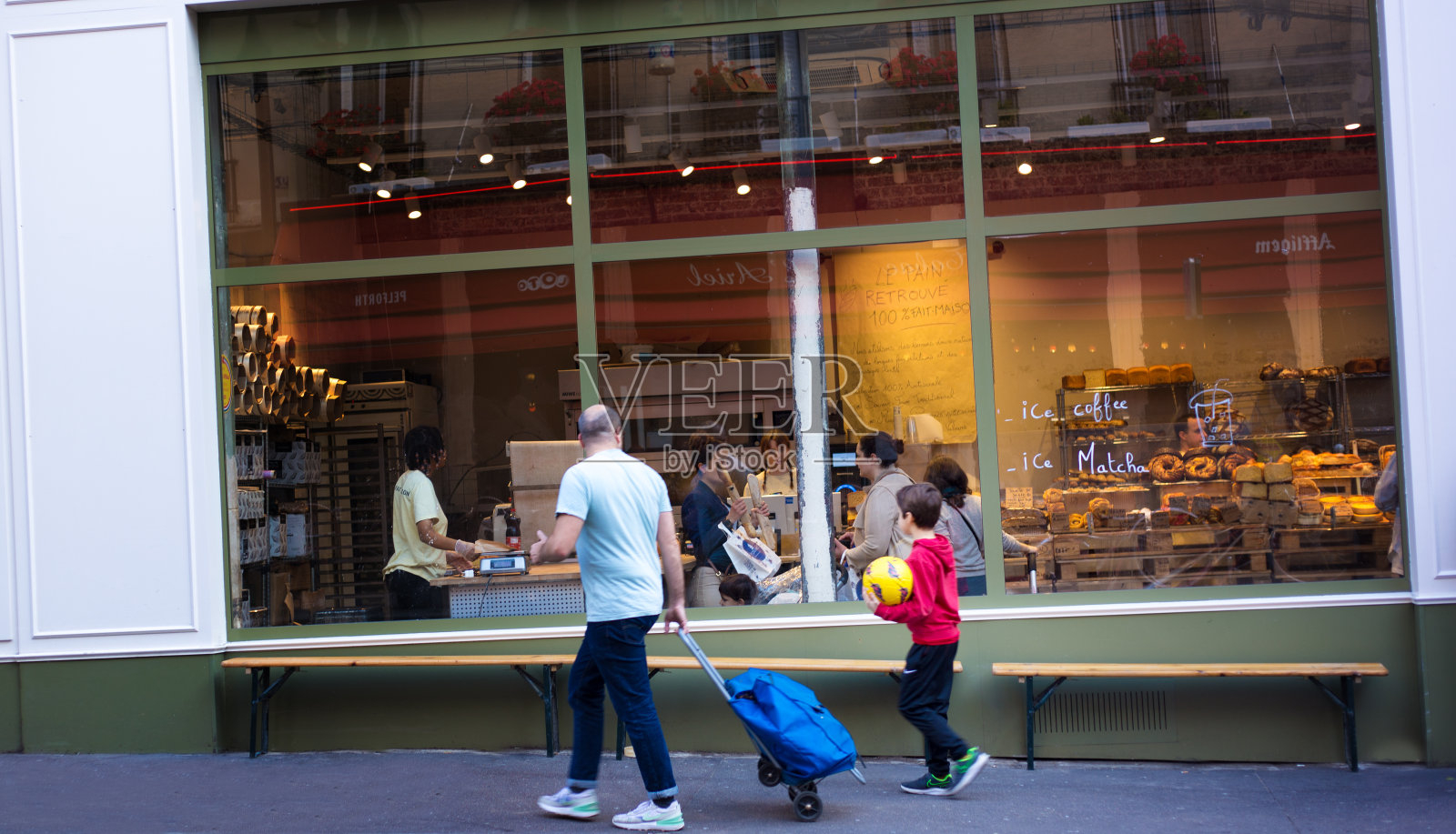 法国，巴黎:父子走过面包店照片摄影图片