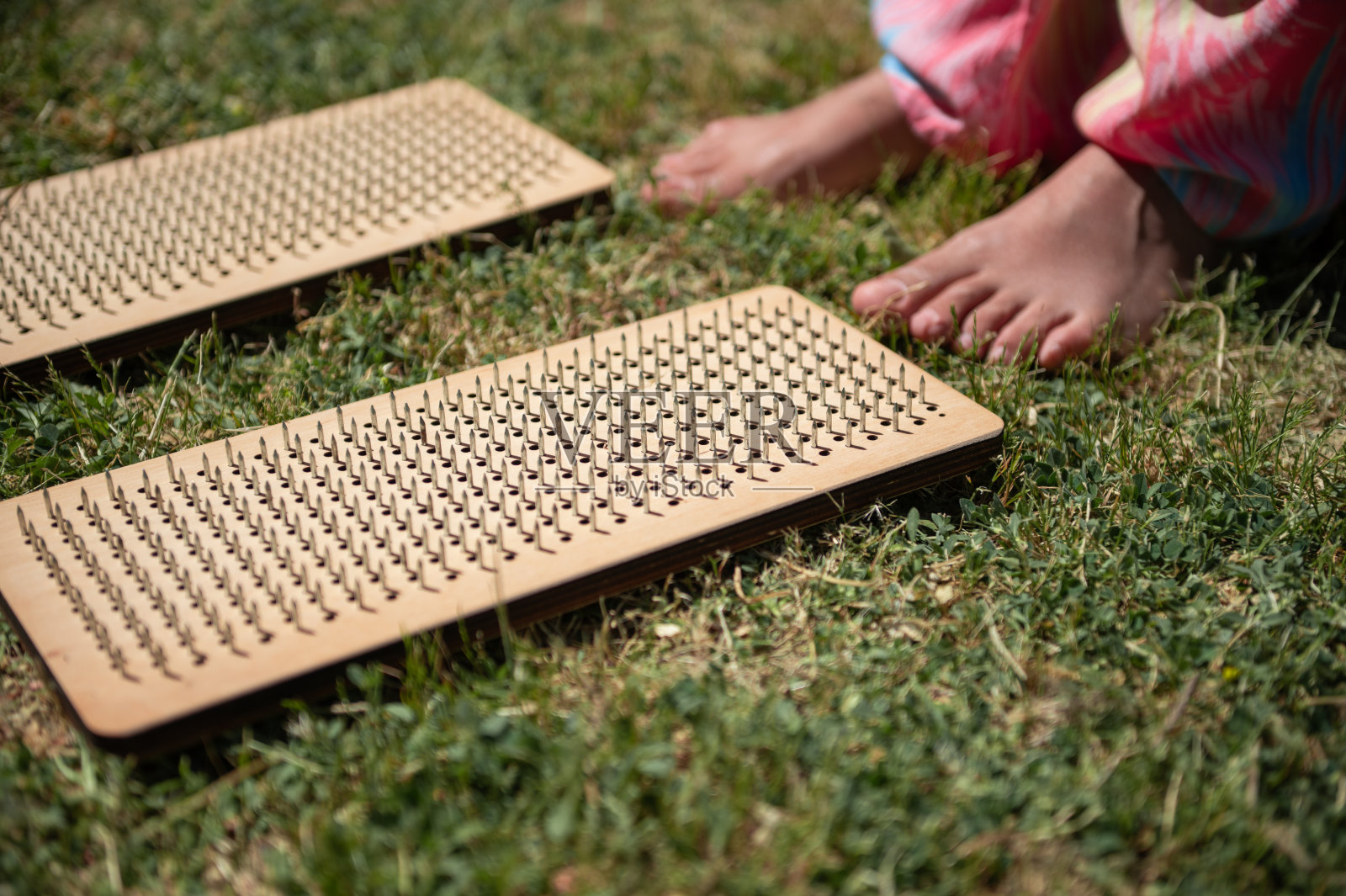 赤脚在户外草地上进行指压疗法照片摄影图片