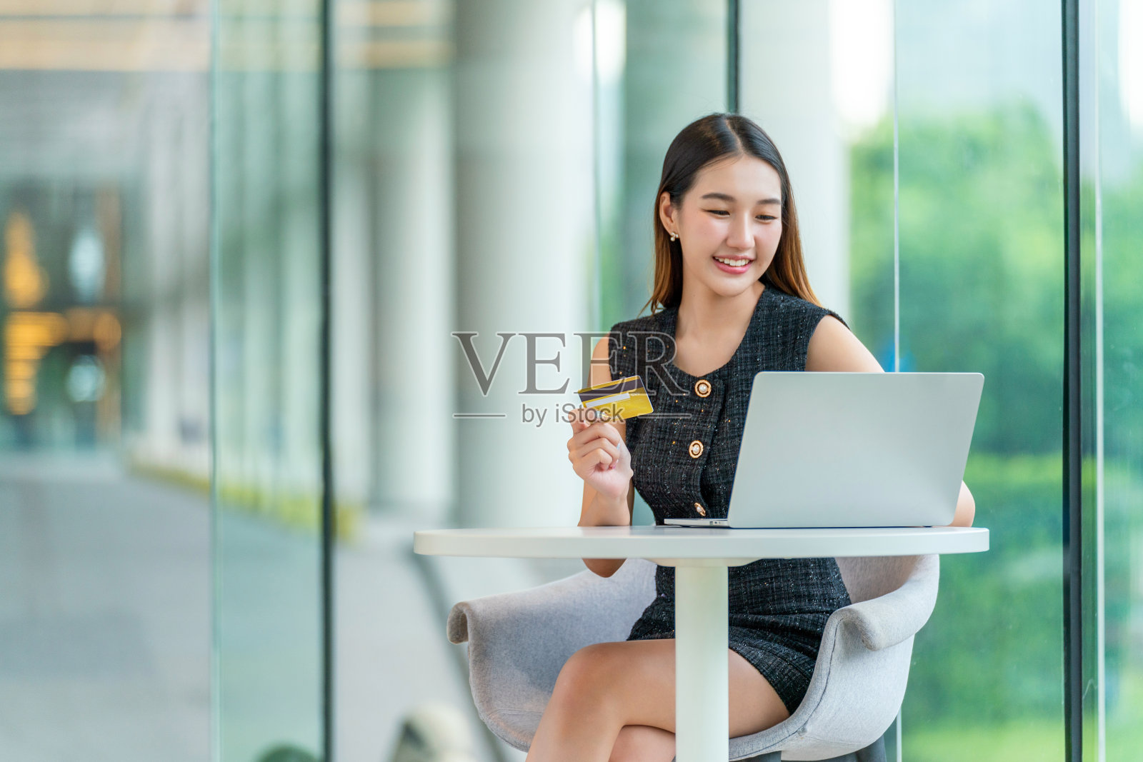 在现代联合办公空间用信用卡网购的年轻女性照片摄影图片