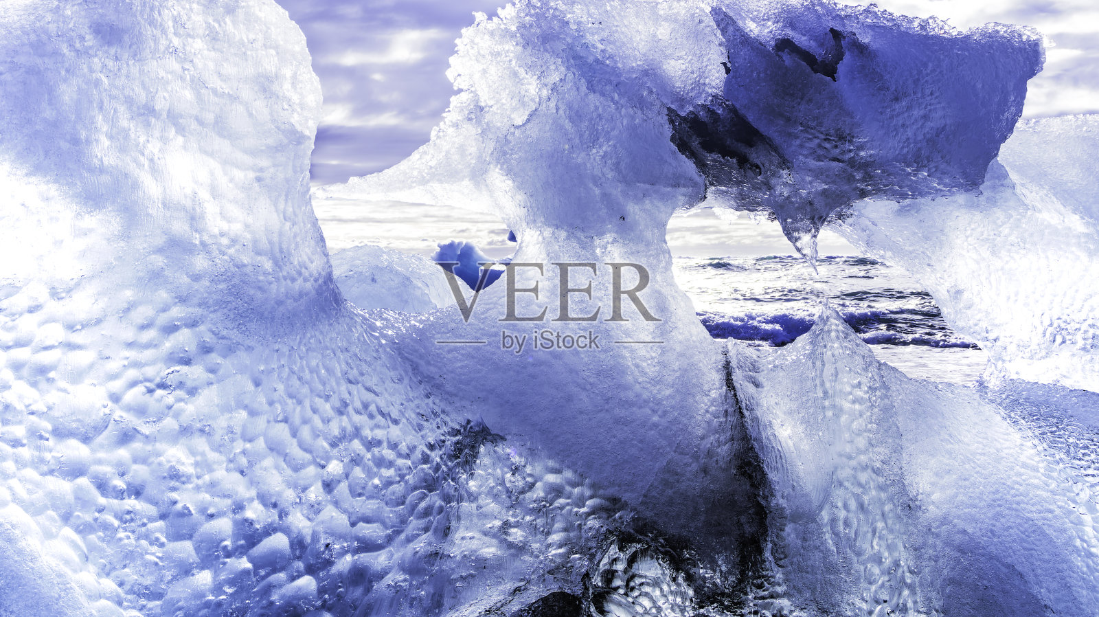 海岸上形成了巨大的冰。透过它的凹凸不平，你可以看到大海照片摄影图片