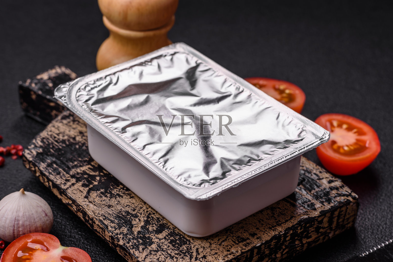 装有酸奶或奶酪的矩形塑料盒，用铝箔盖密封照片摄影图片