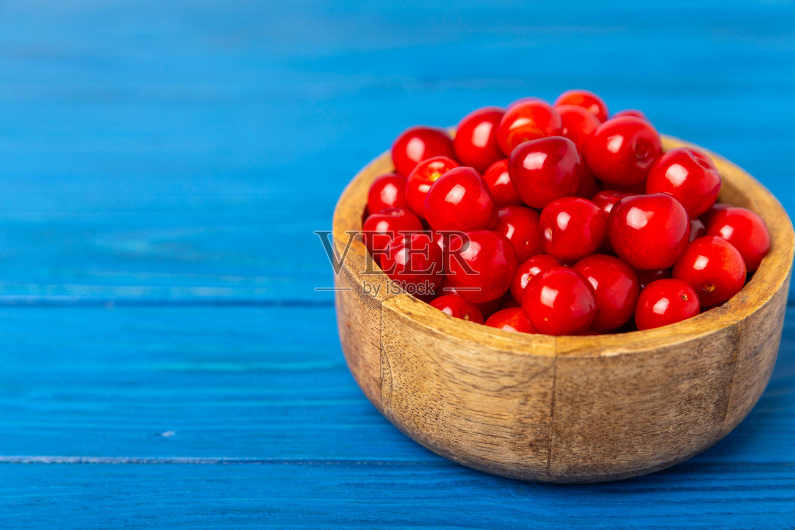 樱桃。新鲜成熟的樱桃和树叶在木质纹理的背景下。新鲜甜美的有机樱桃堆。浆果和水果。素食主义者。健康饮食。放文字的地方。本空间照片摄影图片