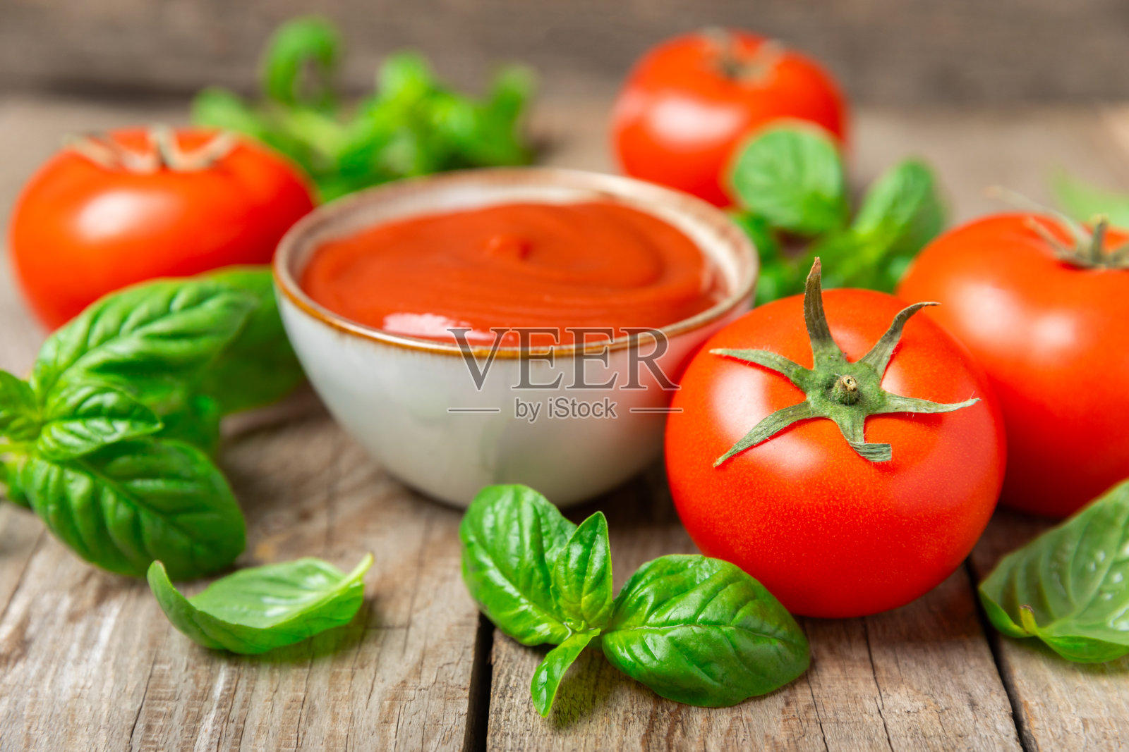 新鲜的圣女果和新鲜的绿色罗勒在纹理的背景。番茄酱。素食主义者。沙拉的配料。有机食品。放文字的地方。副本的空间。照片摄影图片