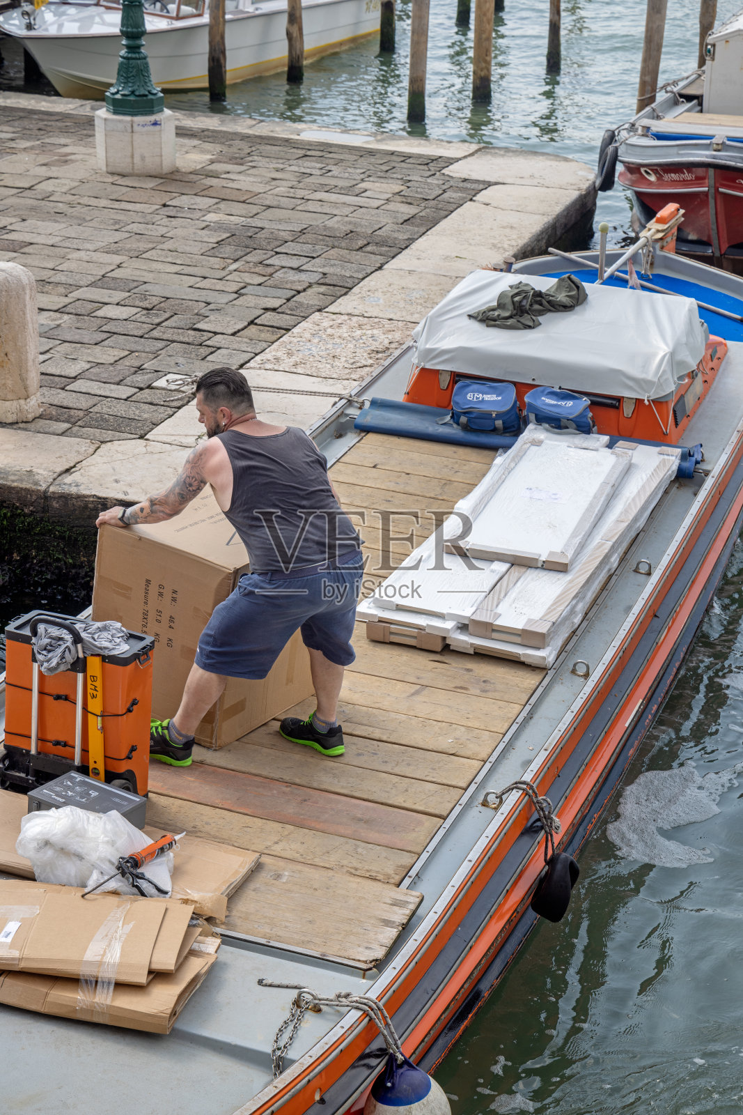 男子从船上卸下板条箱照片摄影图片