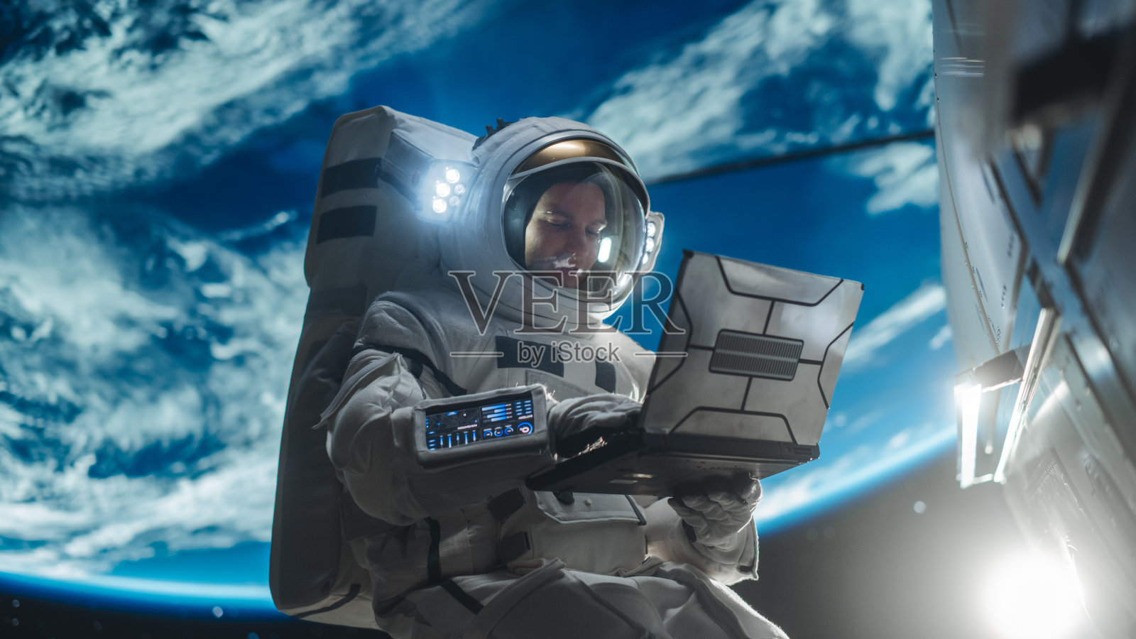 男宇航员用笔记本电脑无线连接卫星。宇航员在地球大气层外的开放空间中工作。承接服务、维修工作的专业工程师照片摄影图片