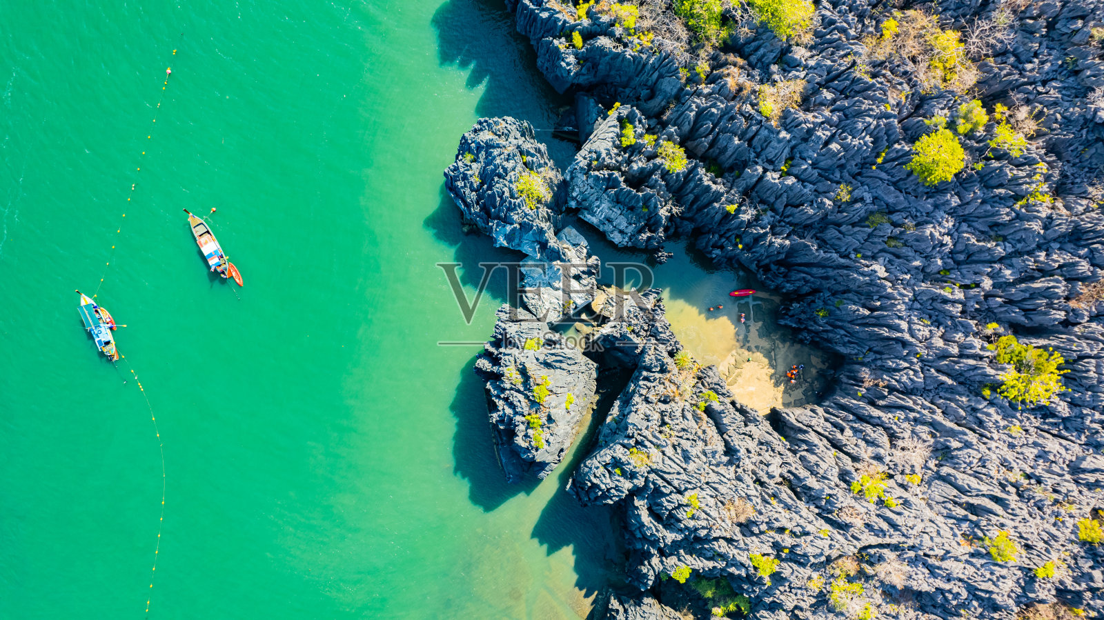 在亚洲泰国南部的沙敦省，游客们划船游览海中的小岛。照片摄影图片