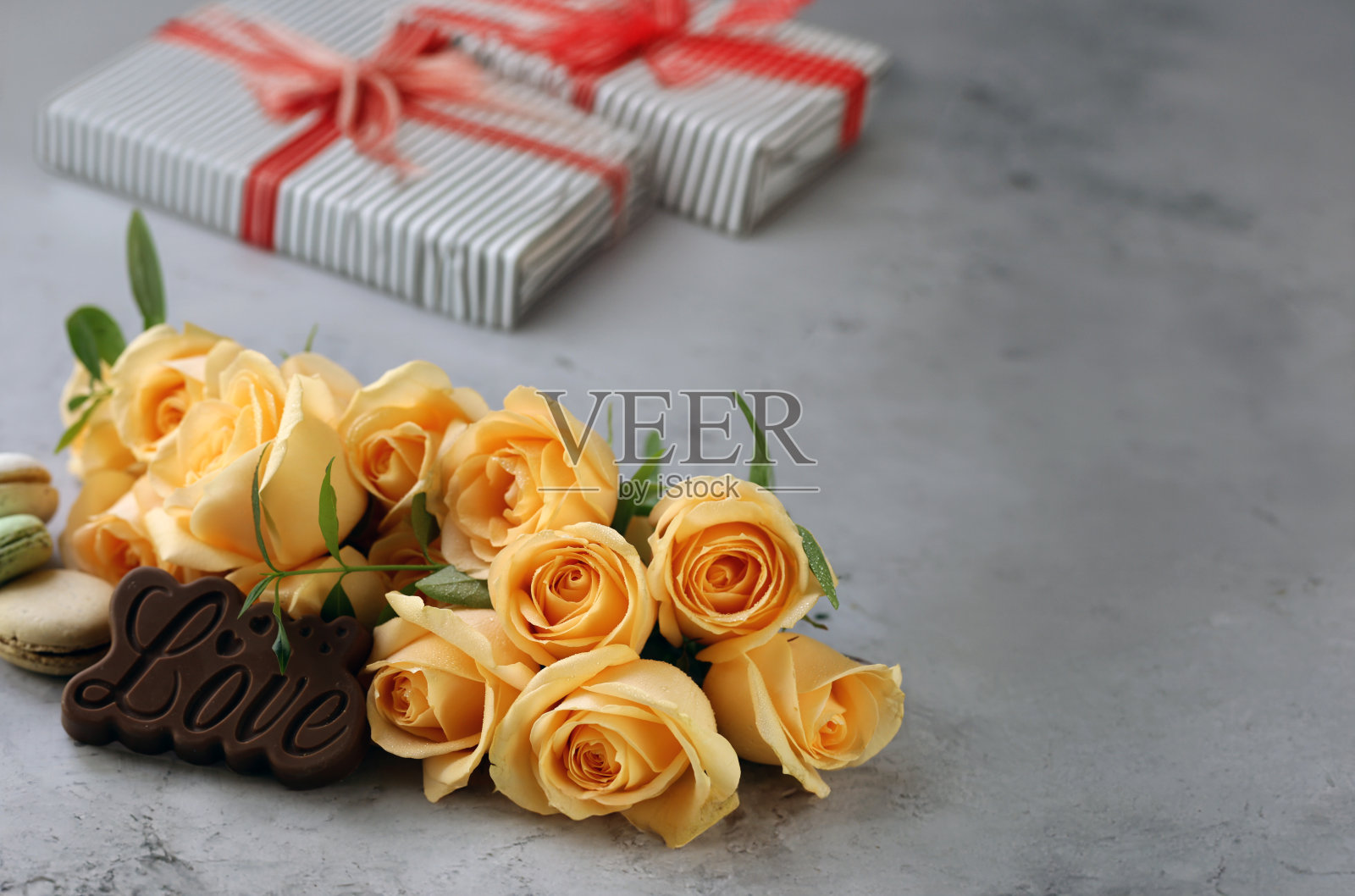 献上一束玫瑰和礼盒，祝贺你和你的节日照片摄影图片