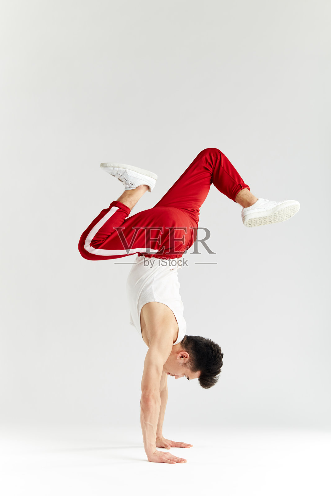 韩国舞者在白色上执行下摇滚霹雳舞的基本冻结照片摄影图片