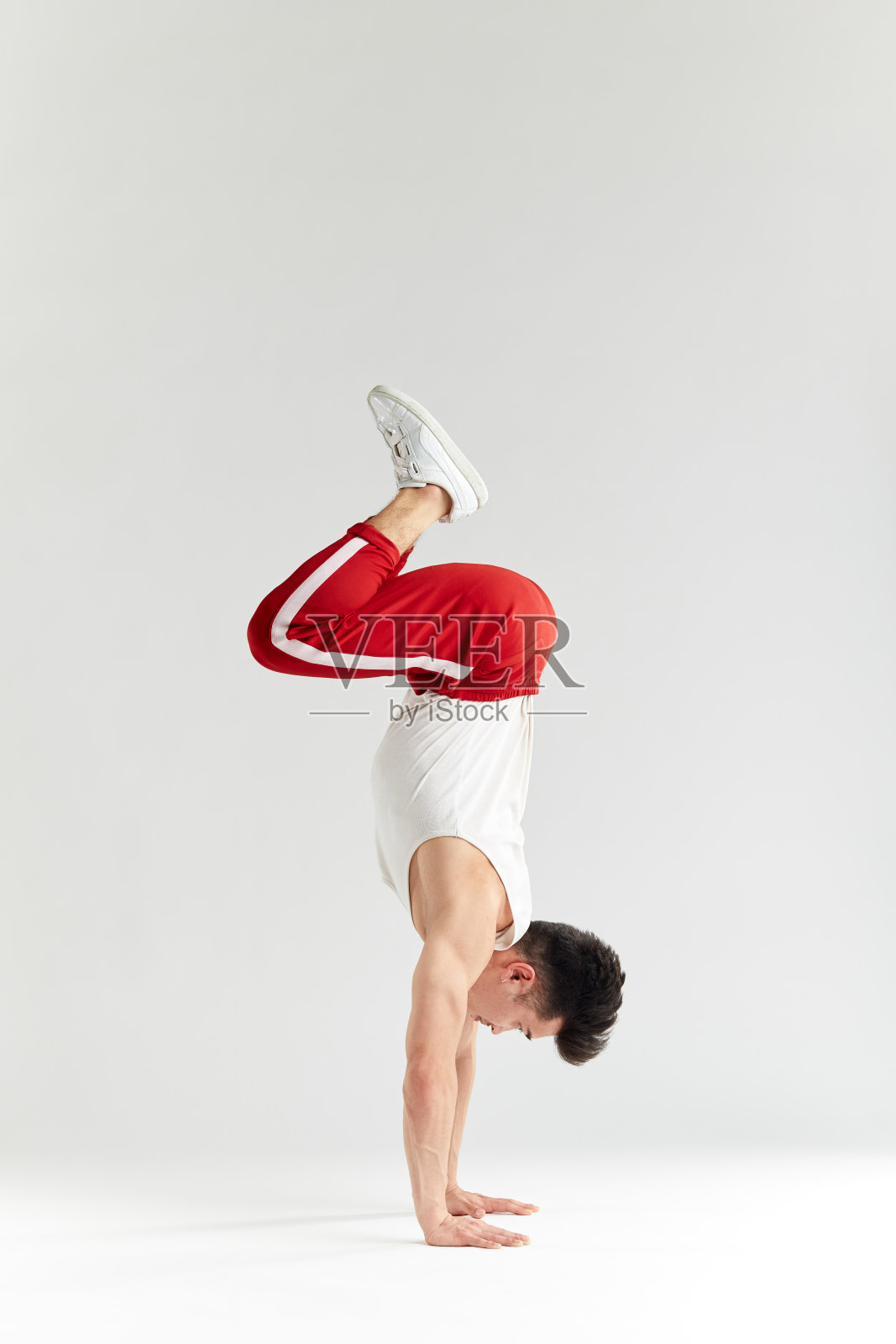 韩国舞者在白色上执行下摇滚霹雳舞的基本冻结照片摄影图片