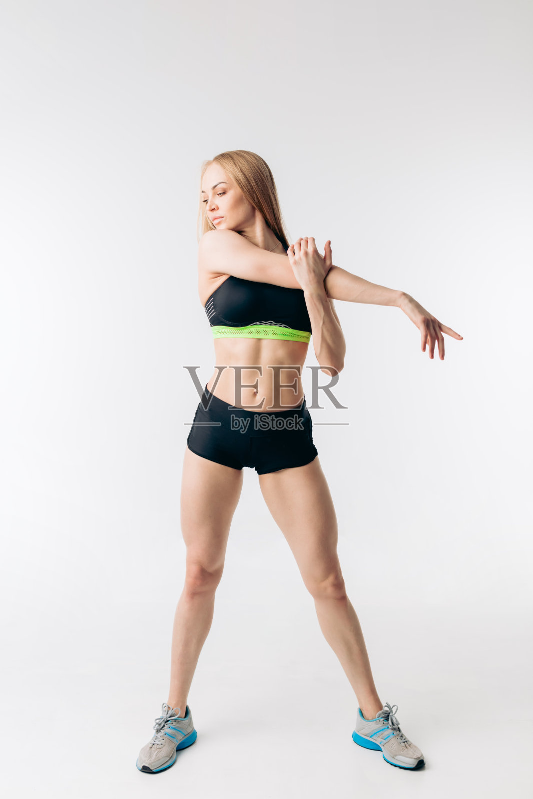 可爱的金发女孩穿着时髦的衣服，在锻炼前做热身照片摄影图片