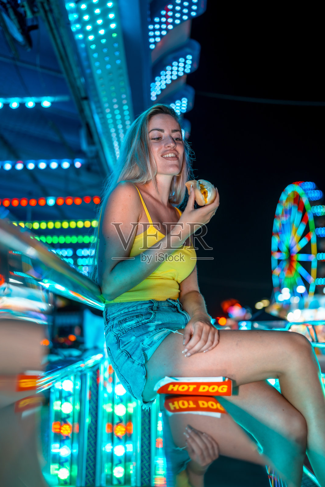 金发女人在夜市享用热狗照片摄影图片