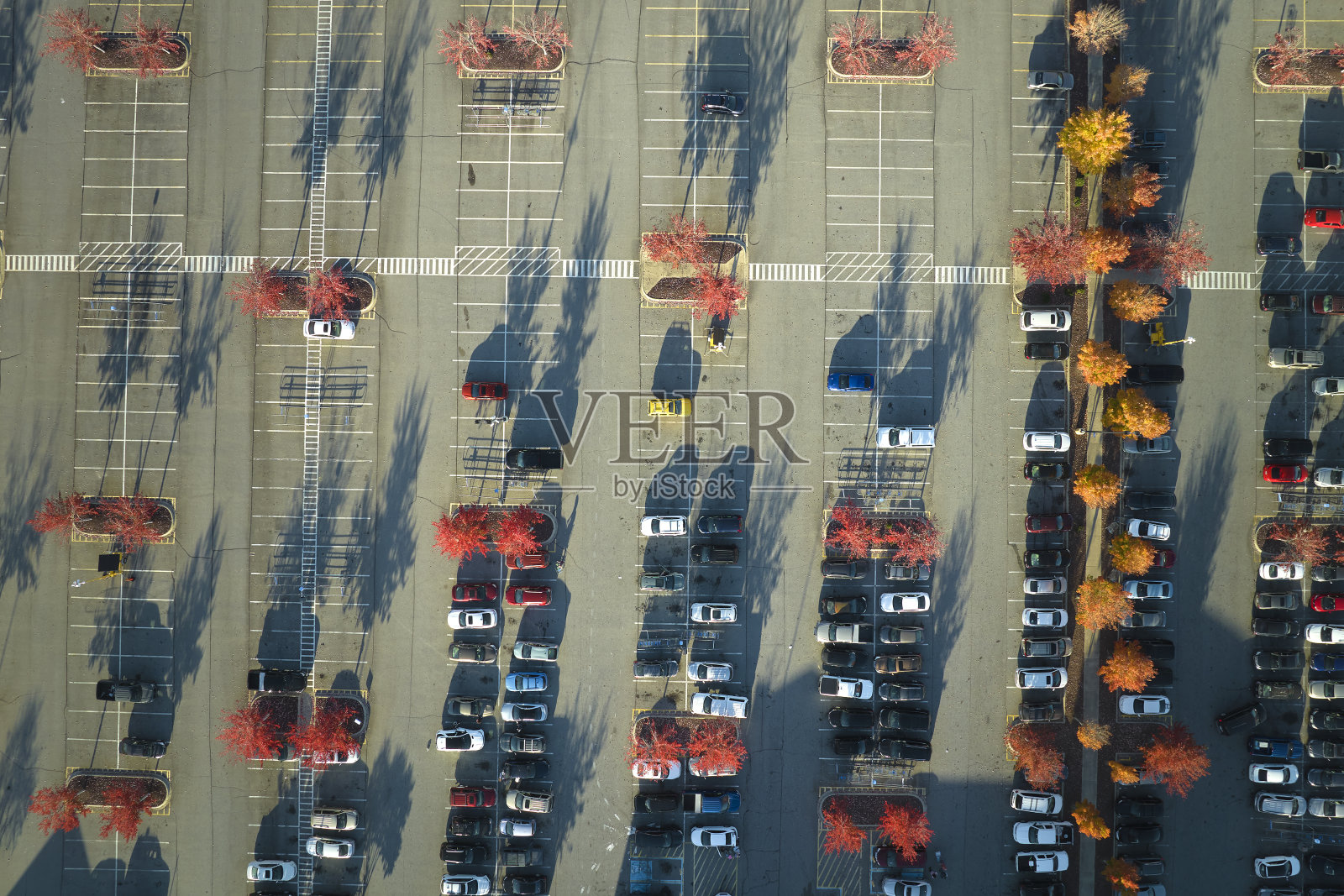从上面看到停车场上许多停放的汽车，上面有停车位置和方向的线条和标记。在一个购物中心前停放车辆的地方照片摄影图片
