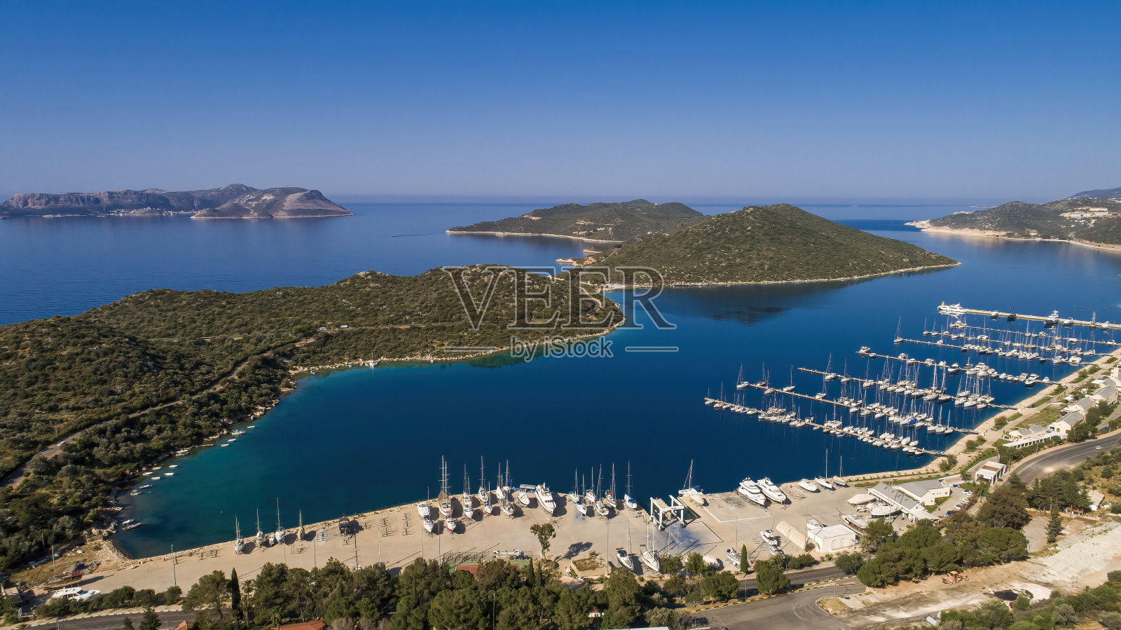 安塔利亚,Kaş。航拍的码头与清澈的海水。帆船整齐排列的港口。以岛屿和树木为背景的壮丽景色。照片摄影图片