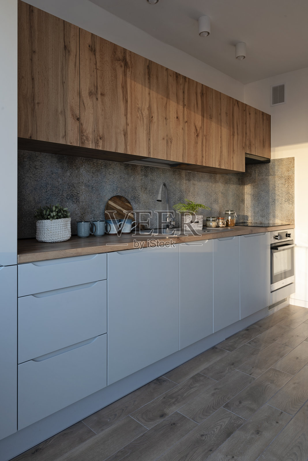 餐厅内的现代厨房，配有木制台面，厨房水槽和墙上的图案瓷砖。家居装饰。照片摄影图片