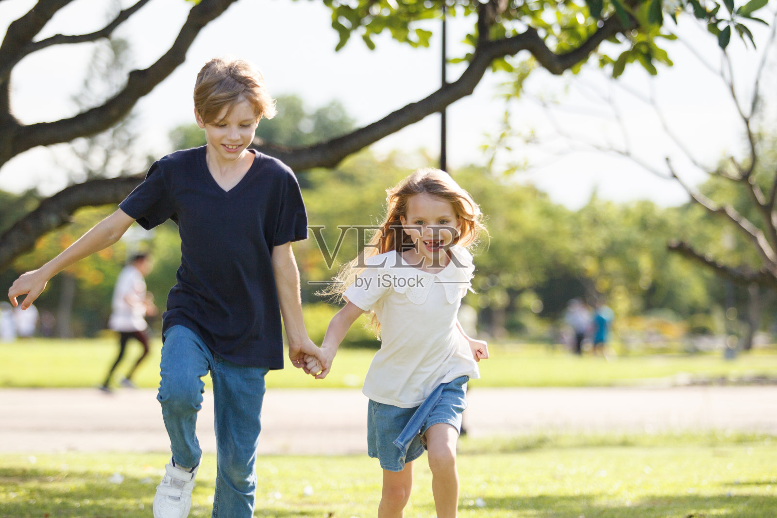 可爱的孩子们在公园里一起玩耍或奔跑。照片摄影图片