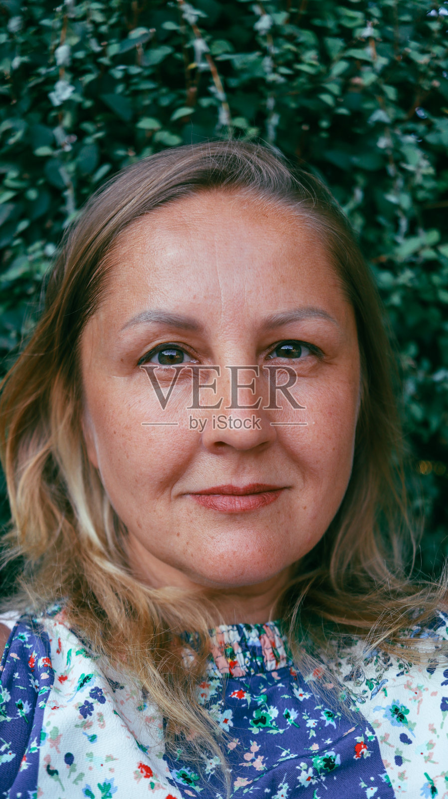 成熟的欧洲外表的女人特写与公园背景在夏天照片摄影图片
