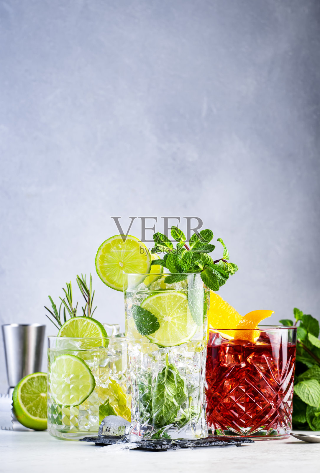 夏季酒精鸡尾酒:灰色背景的凯普林哈、伏特加汤力和内格罗尼照片摄影图片