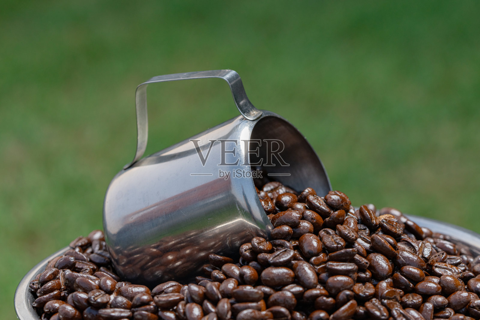 咖啡豆从杯子里洒出来。照片摄影图片