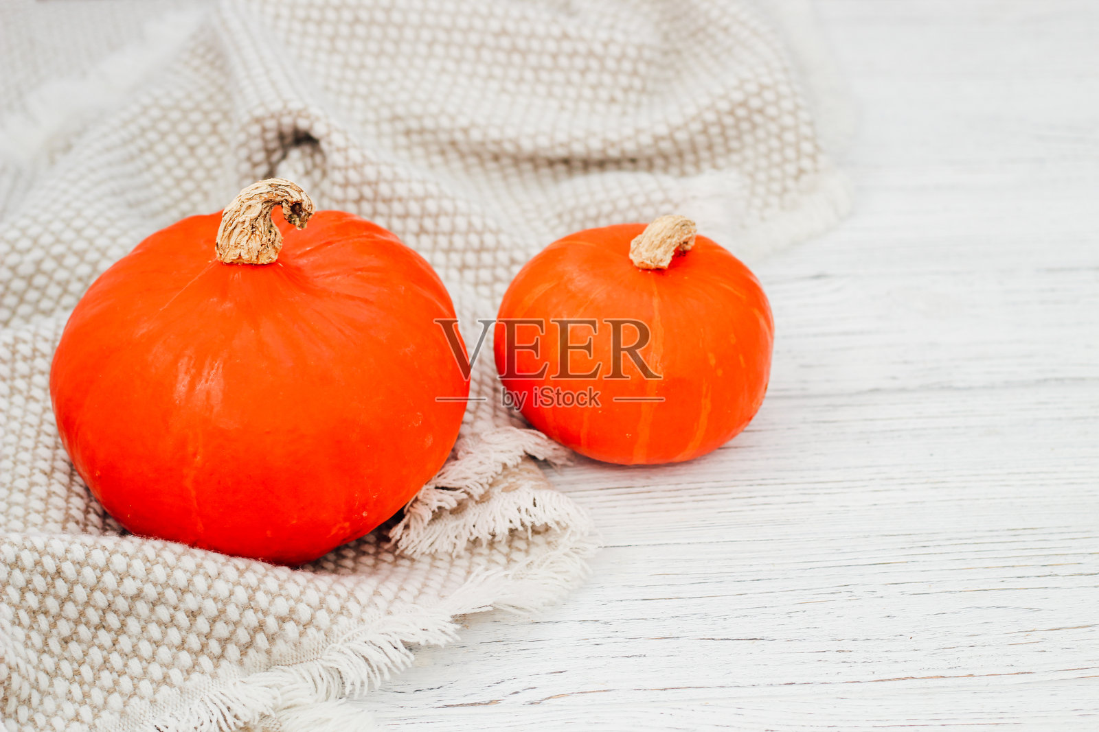 两个黄色的南瓜在灰色温暖的毯子上照片摄影图片