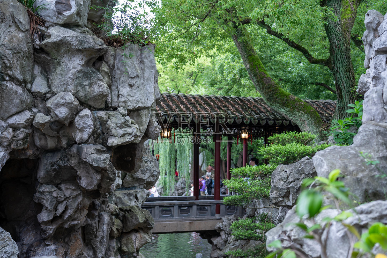 在宁静的上海豫园，透过岩石一瞥传统的中国亭子。照片摄影图片