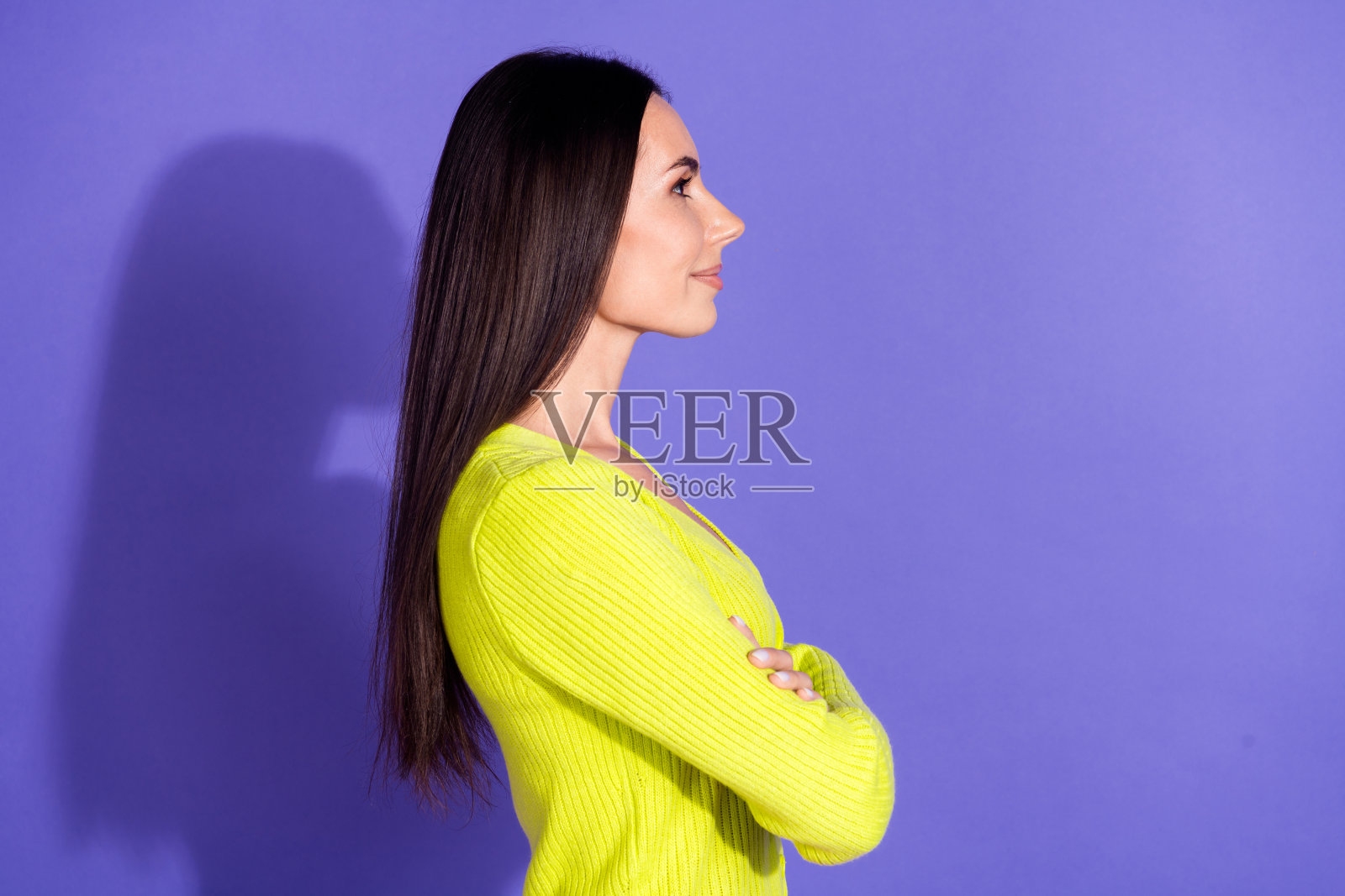 侧面照片的华丽可爱的好女孩穿着时尚的衣服，在紫色的背景空的空间孤立照片摄影图片