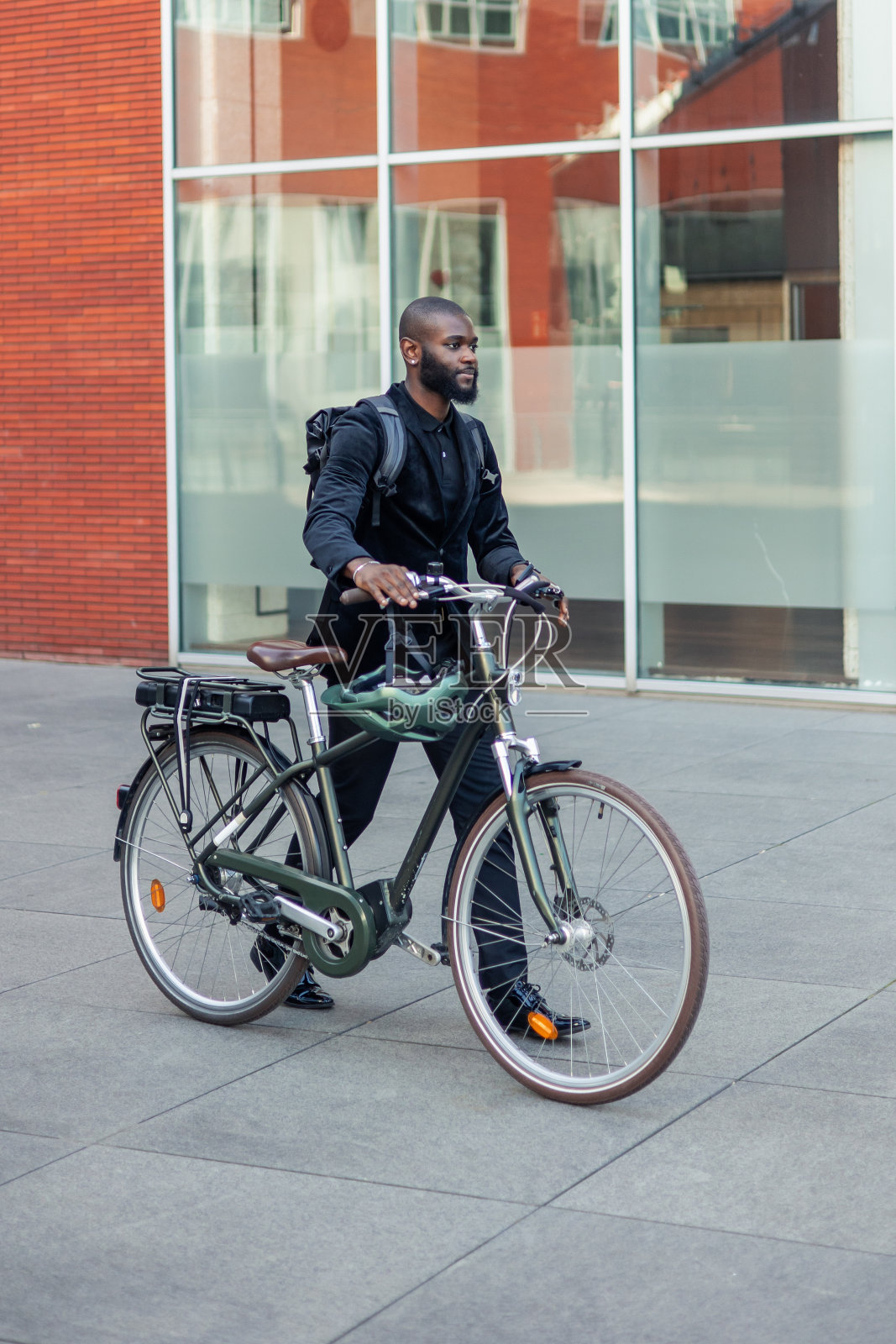 快乐的非洲黑人商人骑着电动自行车在市中心商业区通勤照片摄影图片