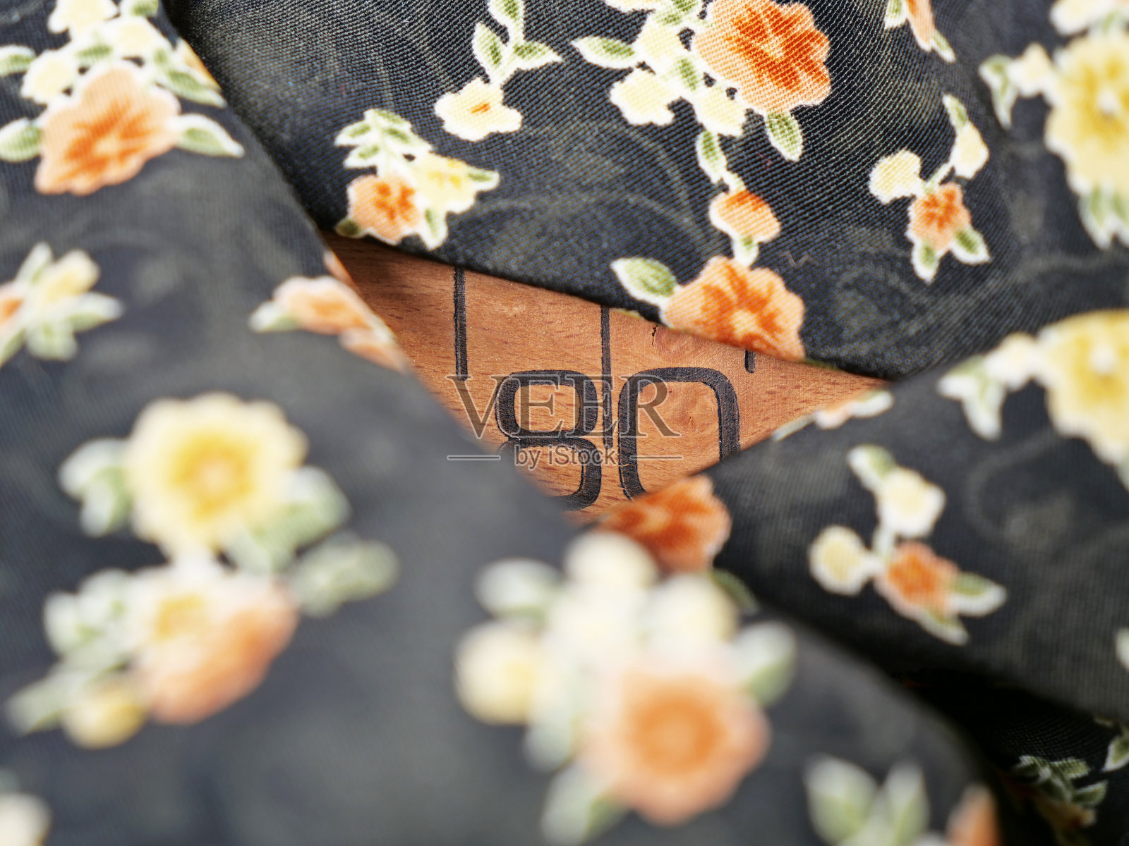 在雪纺织物背景上的木制卷尺照片摄影图片